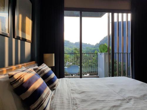Un dormitorio con una cama grande y un balcón. en Baan S.W.A.T by 23 Degree Khao Yai, en Ban Huai Sok Noi