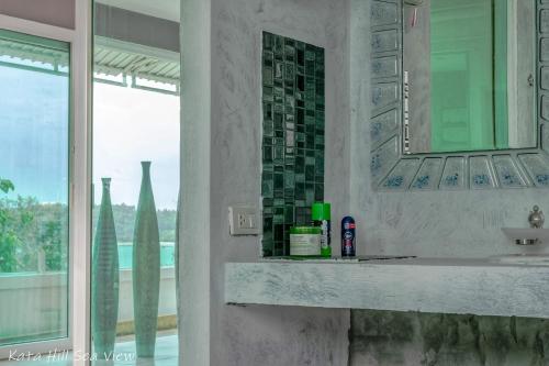 a bathroom with a sink and a mirror and a window at KATA PENTHOUSE SEA VIEW private POOL in Kata Beach