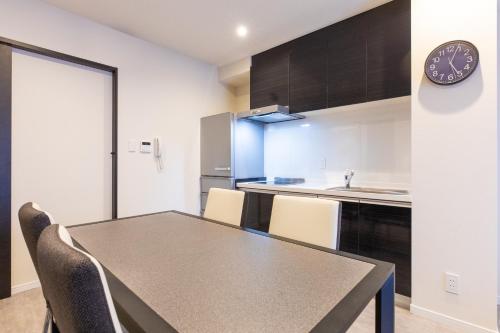 a kitchen and dining room with a table and chairs at LAPIN MIHAMA Residence Hotel in Chatan