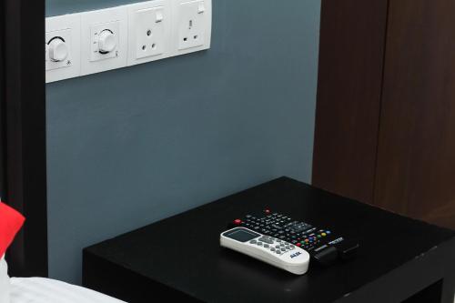 a remote control sitting on top of a black table at Golden Pier City Hotel in Colombo
