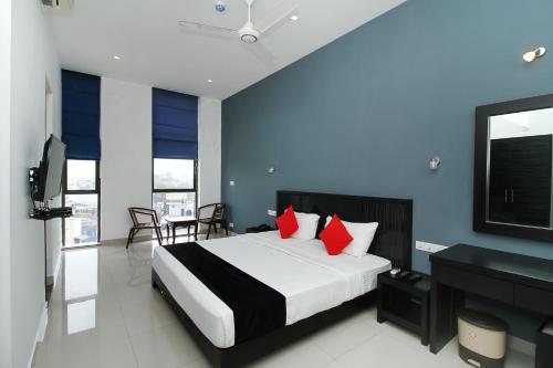 a bedroom with a large bed with red pillows at Golden Pier City Hotel in Colombo