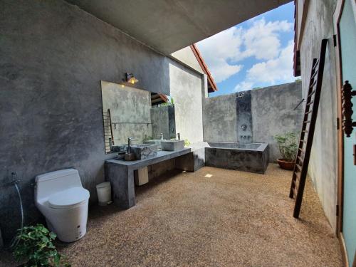 a bathroom with a toilet and a sink and a tub at Tropicana Lanta Resort in Ko Lanta