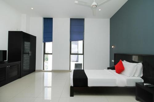 a bedroom with a bed with a red pillow at Golden Pier City Hotel in Colombo