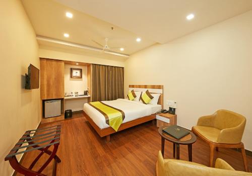 a hotel room with a bed and a chair at Taz Kamar Family Hotel in Chennai