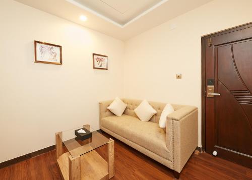 a living room with a couch and a table at Taz Kamar Family Hotel in Chennai