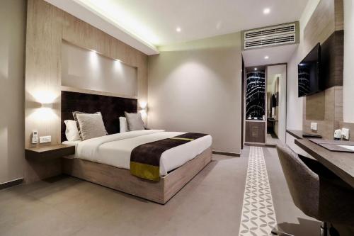 a large bedroom with a large bed and a desk at Kingston Resort in Kānpur