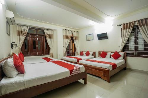 a bedroom with two beds with red pillows at Windy River Homestay in Hoi An
