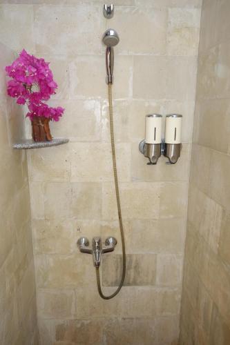 a shower with a hose attached to a wall at Gili Palms Resort in Gili Trawangan