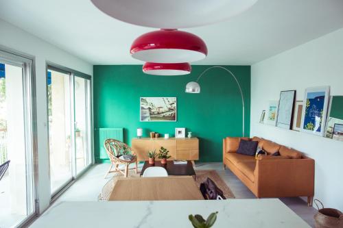 een woonkamer met een bank en een groene muur bij Le Canaillou par Dodo-a-Cassis in Cassis