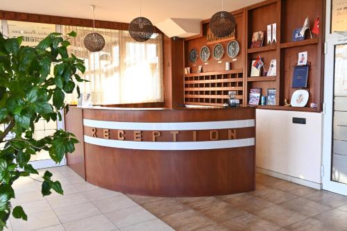 a restaurant with a reception counter in a room at Harmony Hotel in Kumanovo