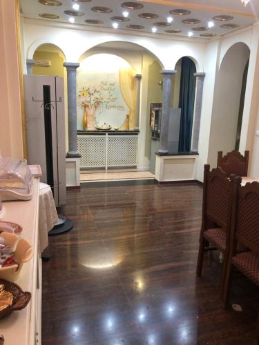 ブレシアにあるB&B ラ テラッツァのテーブルと椅子、床が備わる広い客室です。