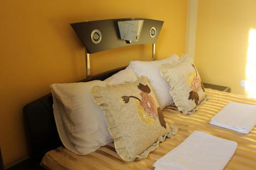 a bedroom with a bed with pillows on it at Villa Atina in Stara Pazova