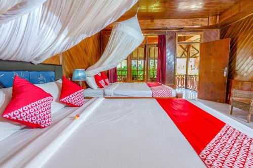 1 dormitorio con 1 cama grande con almohadas rojas y blancas en Gusung Indah Bungalow Gili Air en Gili Air