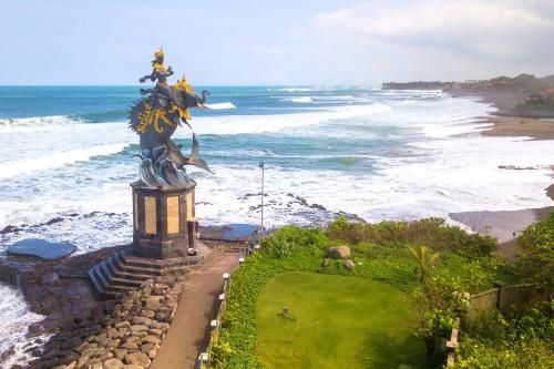 a statue of a woman standing next to the ocean at Sau Bali Beach House Canggu in Canggu