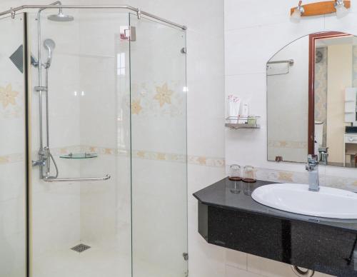 a bathroom with a glass shower and a sink at Sun & Sea Hotel in Phu Quoc