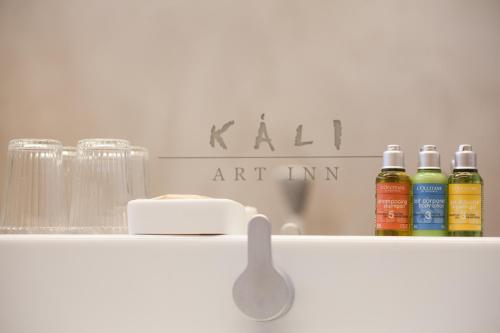 a shelf with three bottles of oil and a sign at Káli Art Inn in Köveskál