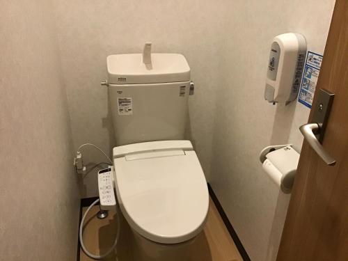 a bathroom with a white toilet in a stall at Kakunodate Guest House Choux in Senboku