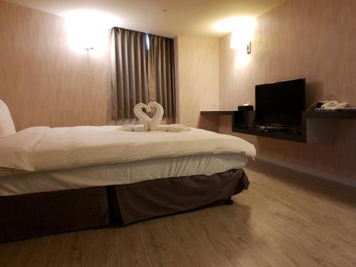 a hotel room with a bed with two swans on it at Walker Hotel - Sanchong in Taipei