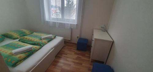 a small bedroom with a bed and a window at Pod Vinicí in Mikulov