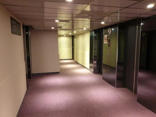 an empty hallway in an office building with purple carpet at Walker Hotel - Sanchong in Taipei