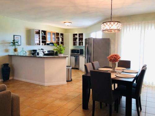 a kitchen and dining room with a table and a refrigerator at Mariposa Beach House in Humacao