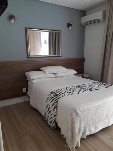 um quarto com uma cama grande e uma janela em Ap pe na areia em ingleses - Florianópolis SC em Florianópolis
