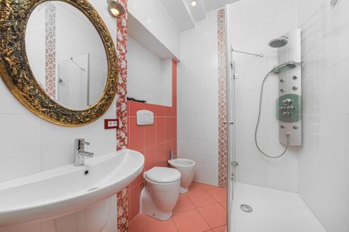 un bagno con lavandino, WC e specchio di Deribasivska Vip 4-room Apartment a Odessa