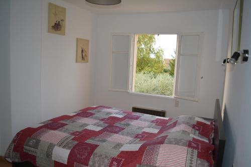 une chambre avec un lit et une fenêtre dans l'établissement Maison le Pastaga, à Caromb