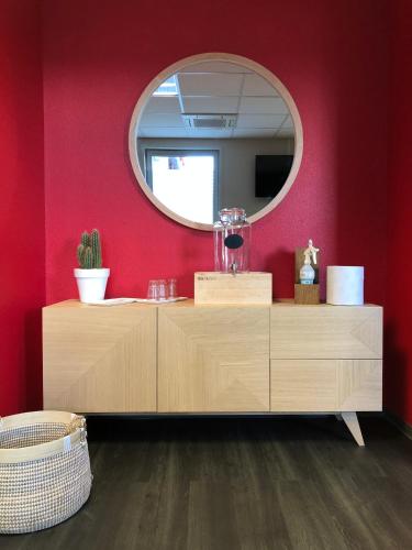 a bathroom with a mirror and a wooden dresser at Ibis Saint-Genis-Pouilly Genève in Saint-Genis-Pouilly