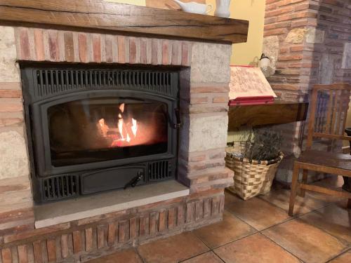 a brick fireplace with a fire in it at La Cabala de Ibeas in Ibeas de Juarros