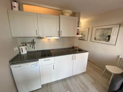 eine Küche mit weißen Schränken und einem Waschbecken in der Unterkunft Apartment Susanne in Benidorm