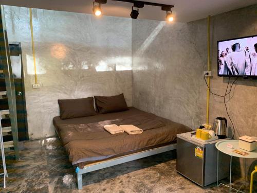 a bed in a room with a tv on a wall at BeachBox@Koh Сhang in Ko Chang