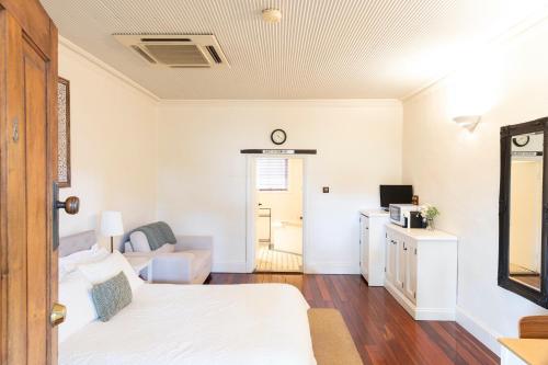 a bedroom with a white bed and a white refrigerator at Kaesler Cottages in Nuriootpa
