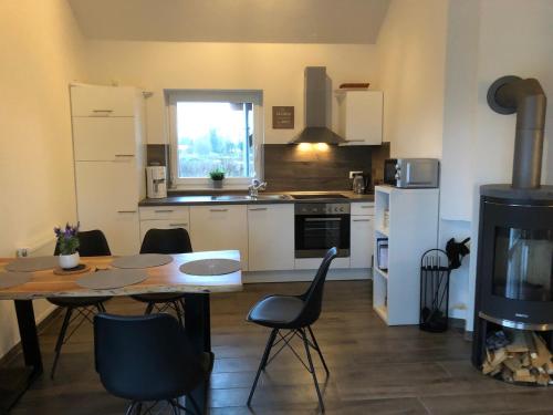 a kitchen with a table and a table and chairs at Ferienhaus Wattkieker in Sehestedt