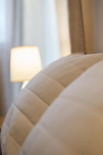 a close up of a pillow on a bed with a lamp at Vasilios Marinos Rooms in Korinthos