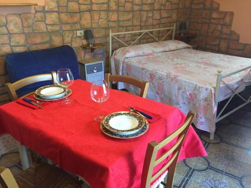 einen Tisch mit einem roten Tischtuch und Gläsern darauf in der Unterkunft MONOVAPELO in Marina di Campo