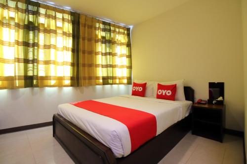 a bedroom with a large bed with two red pillows at Super OYO 484 Pannee Residence Khaosan Sha Plus in Bangkok