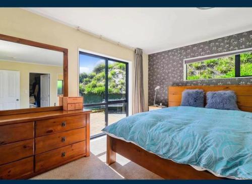 una camera con letto, specchio e cassettiera di Sweet Home a Rotorua