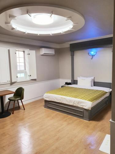 een slaapkamer met een bed en een groot plafond bij Hill Motel in Gyeongju
