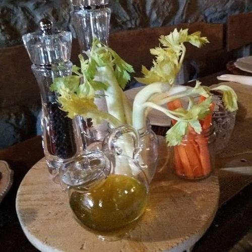 a table with a plate of vegetables in glass vases at Agriturismo Frantoio Valiani in Cortona