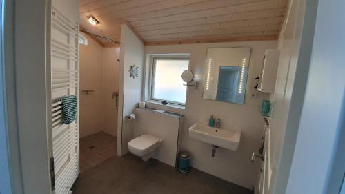a bathroom with a toilet and a sink and a window at Haus Seeblick in Timmendorfer Strand