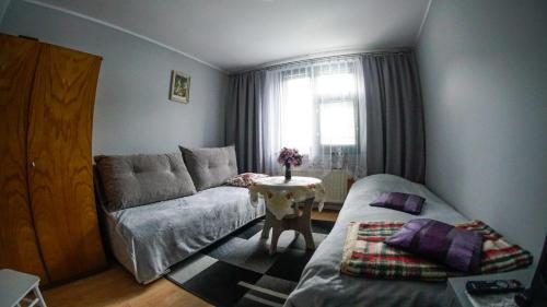 シュチルクにあるPokoje Gościnne u Renatyのベッド1台、テーブル、ソファが備わる客室です。