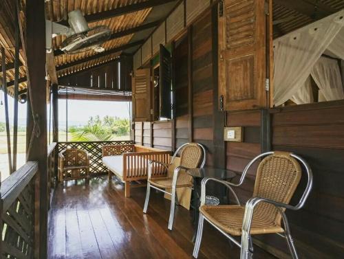 a dining room with chairs and a table in a cabin at tanabendang banglos in Pantai Cenang