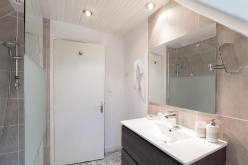 ein Bad mit einem Waschbecken, einer Dusche und einem Spiegel in der Unterkunft LA MAISON DES CHEVAUX in Eu