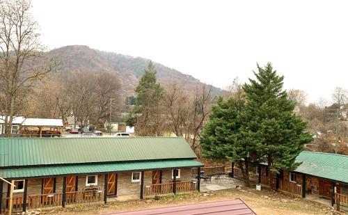 a large wooden building with a green roof at Spring Creek Hotel in Hot Springs