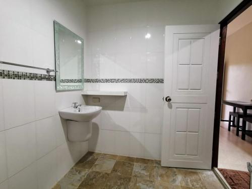 a white bathroom with a sink and a mirror at SER-EN-DIP-I-TY - SHA Extra Plus in Ko Lanta