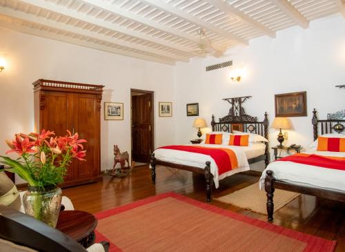 a bedroom with two beds with red and orange pillows at Le Colonial 1506 - Exclusive Luxury Hideaway in Cochin