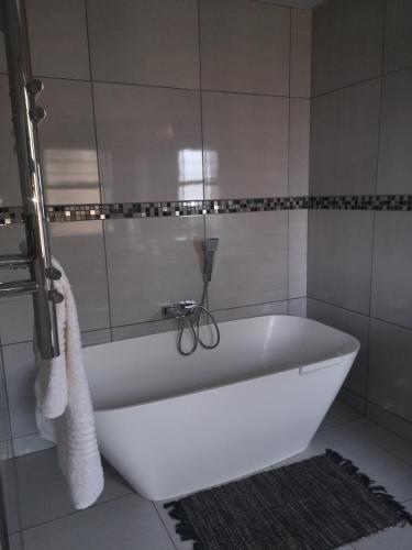 a white bath tub sitting in a bathroom at 8 Sleeper Villa and 4 Sleeper Flatlet in Clarens