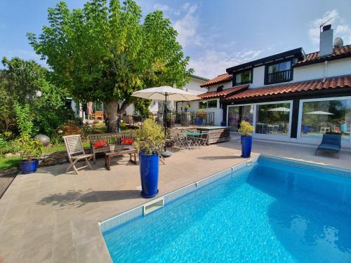 a house with a swimming pool in front of a house at Domaine de Millox in Saint-André-de-Seignanx