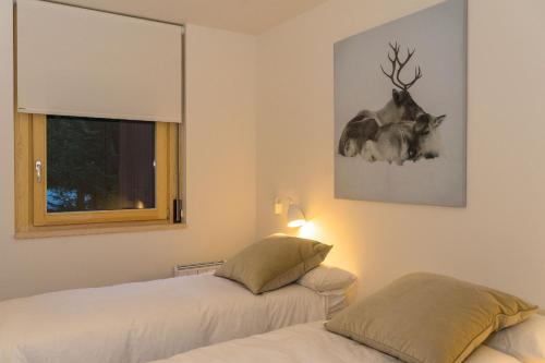 a bedroom with two beds and a picture of a moose at Airoto by Totiaran in Baqueira-Beret